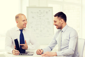 Image showing two smiling businessmen with laptop in office