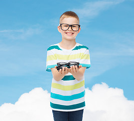 Image showing smiling boy in eyeglasses holding spectacles