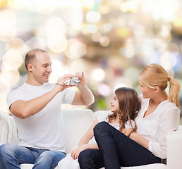 Image showing happy family with camera at home