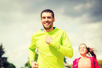 Image showing smiling couple running outdoors