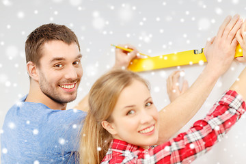 Image showing couple building using spirit level to measure