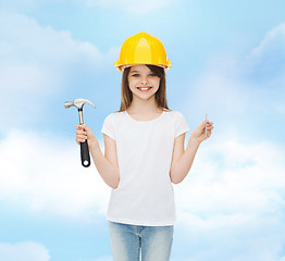 Image showing smiling little girl in hardhat with hammer