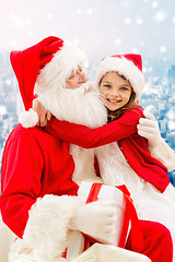 Image showing smiling little girl with santa claus and gifts