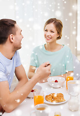 Image showing smiling couple having breakfast at home