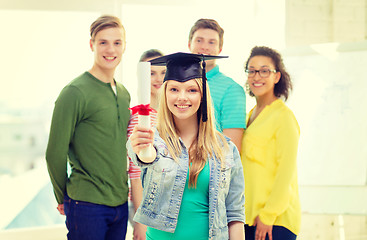 Image showing smiling female student with diploma and corner-cap