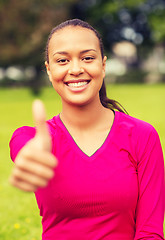Image showing smiling african american woman showing thumbs up