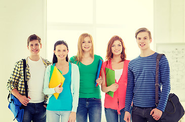 Image showing smiling students with bags and folders at school