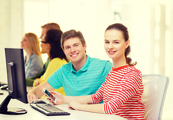 Image showing smiling student with smartphone in computer class