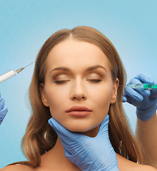 Image showing beautiful woman face and hands with syringe