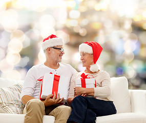 Image showing happy senior couple in santa hats with gift boxes