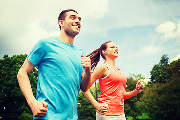 Image showing smiling couple running outdoors