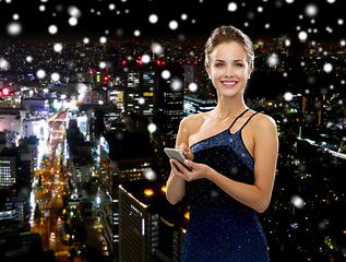 Image showing smiling woman in evening dress with smartphone