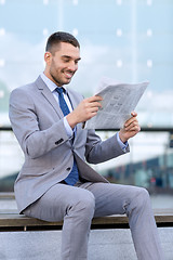 Image showing young smiling businessman newspaper outdoors