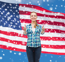 Image showing smiling girl in casual clothes showing thumbs up