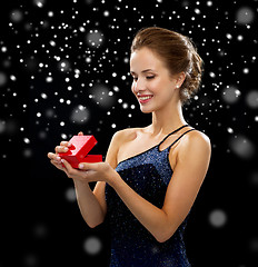 Image showing smiling woman holding red gift box