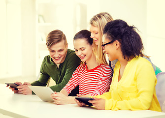 Image showing smiling students looking at tablet pc at school