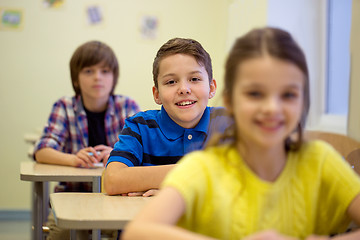 Image showing group of school kids with notebooks in classroom