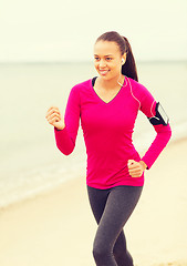 Image showing smiling young woman running outdoors