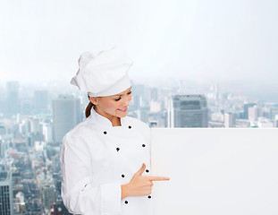 Image showing smiling female chef with white blank board