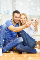 Image showing smiling couple taking picture with digital camera