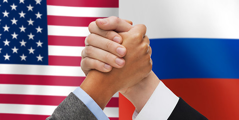 Image showing hands armwrestling over american and russian flags