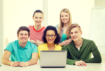 Image showing smiling students with laptop at school