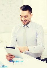 Image showing businessman with tablet pc and files in office