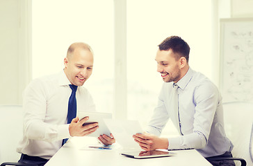 Image showing two smiling businessmen with tablet pc in office