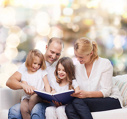 Image showing happy family with book at home