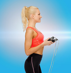 Image showing smiling sporty woman with skipping rope