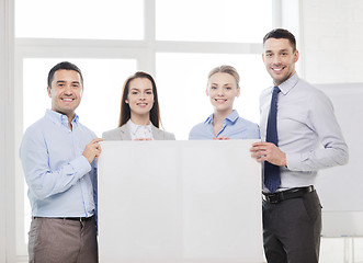 Image showing business team in office with white blank board