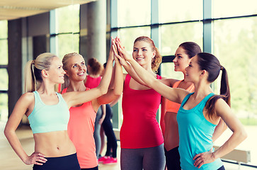 Image showing group of women making high five gesture in gym