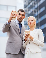 Image showing serious businessmen with paper cups outdoors