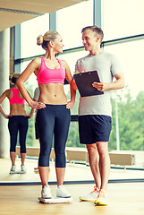 Image showing smiling man and woman with scales in gym