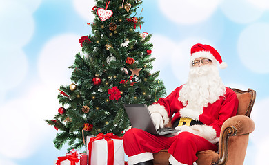 Image showing man in costume of santa claus with laptop