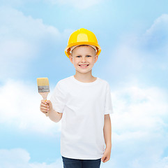 Image showing smiling little boy in helmet with paint brush