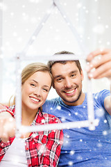 Image showing smiling couple with house made of measuring tape