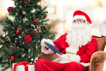 Image showing man in costume of santa claus with tablet pc