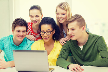 Image showing smiling students looking at laptop at school