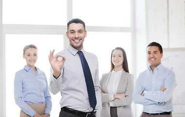 Image showing smiling businessman showing ok-sign in office