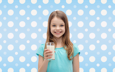 Image showing smiling girl with glass of milk over polka dots