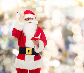 Image showing man in costume of santa claus with notepad