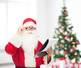 Image showing man in costume of santa claus with notepad