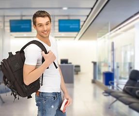 Image showing smiling student with backpack and book at airport