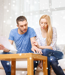 Image showing busy couple with papers and calculator at home