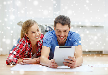 Image showing smiling couple with tablet pc at home