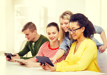 Image showing smiling students looking at tablet pc at school