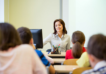 Image showing group of school kids raising hands in classroom