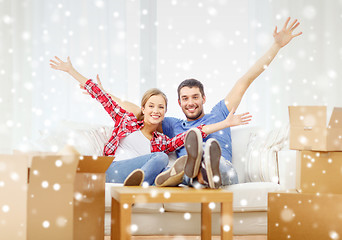 Image showing smiling couple relaxing and waving hand at home