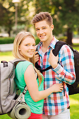 Image showing smiling couple with backpacks in nature